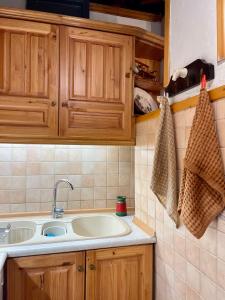a kitchen with a sink and wooden cabinets at Kalyva Cottage in Myrina +26 photos