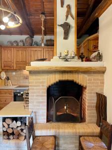 ein Wohnzimmer mit einem gemauerten Kamin in der Küche in der Unterkunft Kalyva Cottage in Mirina