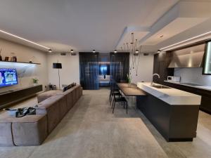 a large living room with a couch and a kitchen at SUNSET SUITE SPA in Staffolo