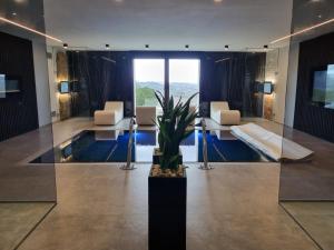 a lobby with a pool and chairs and a table at SUNSET SUITE SPA in Staffolo