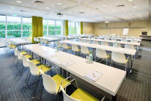 a classroom with tables and chairs in a room with windows at Select Hotel Erlangen in Erlangen