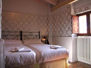 a bedroom with a bed with white sheets and a window at Casa Rural Negua en La Cuenca, Soria in La Cuenca