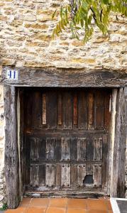 uma porta de madeira na lateral de um edifício em Casa Rural Negua en La Cuenca, Soria em La Cuenca