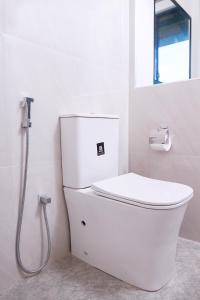 um WC branco numa casa de banho com chuveiro em Oragan Resort em Tissamaharama