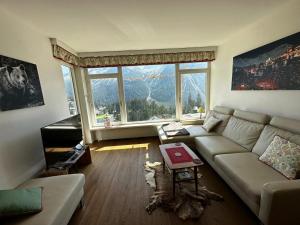 a living room with a couch and a large window at Ritschis Home in Arosa