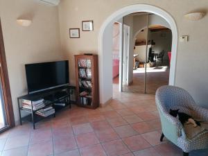sala de estar con TV y silla en Maison au calme entre vignes et Luberon, en Saint-Martin-de-la-Brasque
