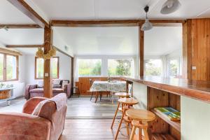 a living room with couches and a kitchen with a counter at La Cabanette à 10min de Disneyland Paris - Cabane & Cabanon in Chalifert