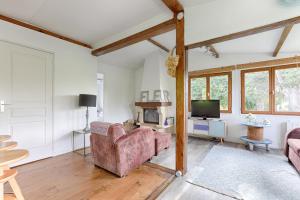 a living room with two couches and a tv at La Cabanette à 10min de Disneyland Paris - Cabane & Cabanon in Chalifert