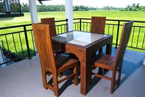 a wooden table and chairs on a porch at Oragan Resort in Tissamaharama