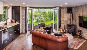 a kitchen and living room with a couch and a fireplace at The Vale Penrose in Penrose