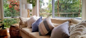 a couch with pillows on it in front of a window at Surf Haven in Lorne