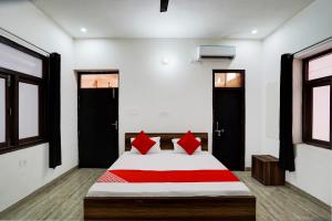 a bedroom with a bed with red pillows on it at OYO Flagship Nakshatram Palace in Kānpur
