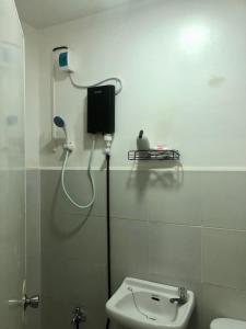 łazienka z toaletą i telefonem na ścianie w obiekcie JMC Homes w mieście Manila