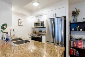 a kitchen with a stainless steel refrigerator and a sink at Near Yonge Finch Subway 2Bed 2Bath Condo Free Parking in Toronto