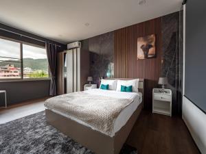 een slaapkamer met een groot bed en een groot raam bij Grand Penthouse by Grand Orlov Hotel in Patong Beach