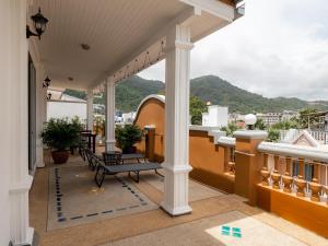 einen Balkon mit einer Bank und Bergblick in der Unterkunft Grand Penthouse by Grand Orlov Apart in Patong Beach