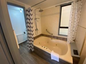 een badkamer met een bad en een raam bij Ace Motor Lodge in Rotorua