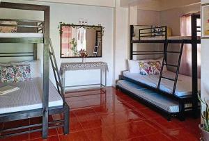a room with three bunk beds and a mirror at RedDoorz @ Mary Land Transient Alaminos Pangasinan in Alaminos