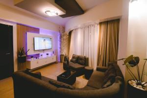 a living room with two couches and a flat screen tv at Davao Rental - AEON Towers Condo 1BR Suite 1Bathroom with Bathtub, Kitchen, Living Room in Davao City +10 photos