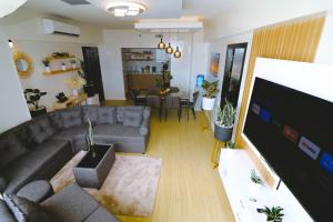a living room with a couch and a flat screen tv at Davao Rental - AEON Towers Condo 1BR Suite 1Bathroom with Bathtub, Kitchen, Living Room in Davao City