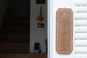 a wooden sign on the side of a house at Near Gangneung Station House in Gangneung