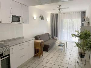 a kitchen and living room with a couch and a table at Coral House - La Calma - Playa Flamenca - big terrace & 4 Swimming pools. in Playa Flamenca