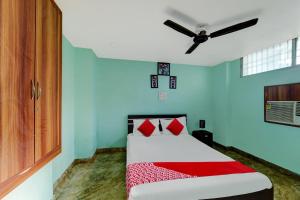 1 dormitorio con cama con almohadas rojas y techo en Degree Hotel, en Dhanbād