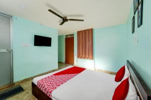 1 dormitorio con 1 cama y ventilador de techo en Degree Hotel, en Dhanbād