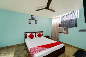 1 dormitorio con 1 cama y ventilador de techo en Degree Hotel, en Dhanbād