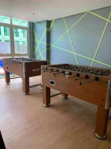 due tavoli da calcio balilla in una stanza con un muro di 1BR with extra room at One Regis- Megaworld a Bacolod