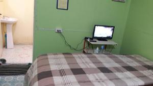 a bedroom with a bed and a computer on a desk at ทรัพย์ทอง การ์เด้น รีสอร์ท in Khao Kho