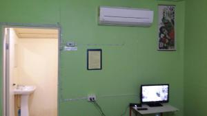 a room with a green wall with a computer on a desk at ทรัพย์ทอง การ์เด้น รีสอร์ท in Khao Kho