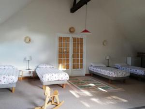 a room with three beds and a table at Le Pressoir de Cour la Ville in Le Mesnil-sur-Blangy