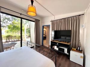1 dormitorio con 1 cama y TV de pantalla plana en Tubtao Sleepy Hill en Pong Talong