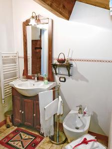 a bathroom with a sink and a toilet and a mirror at Appartamento Augusta - Residenza la Madonina in Morciano di Romagna +14 photos