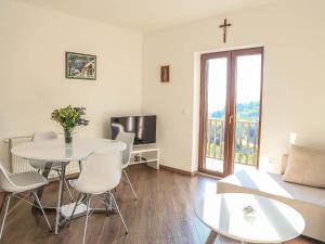 a living room with a table and a cross on the wall at Spacious apartment with private terrace in Pridvorje