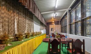 Itsy By Treebo - Sri Mani'S Residency, Coimbatore Airport في كويمباتور: مطعم فيه طاولات وكراسي في الغرفة