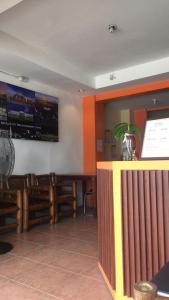 une salle à manger avec des chaises en bois et un bar dans l'établissement RedDoorz at Rio Bella Lacson St Bacolod, à Bacolod