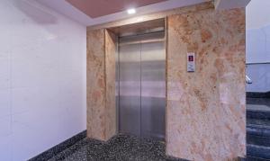 a metal elevator in a room with stairs at Itsy By Treebo - Sri Mani'S Residency, Coimbatore Airport in Coimbatore