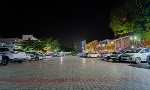 a parking lot with cars parked on a street at night at Itsy By Treebo - Sri Mani'S Residency, Coimbatore Airport in Coimbatore