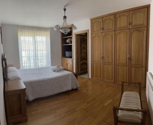 a bedroom with a bed and a large wooden cabinet at Vibes Coruña- Muxía in Castelo