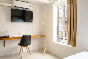 a bedroom with a desk and a chair and a window at Alley & Pier in Bangkok