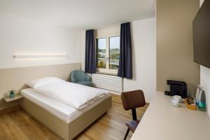 una camera d'albergo con letto e finestra di Hotel an der Reuss a Gisikon
