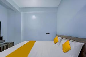 a bed with yellow and white pillows in a room at FabExpress JT Complex in Rānchī