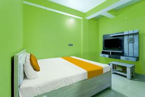 a green room with a bed and a tv at FabExpress JT Complex in Rānchī