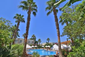 widok na basen w ośrodku z palmami w obiekcie Mandarin Resort & Spa w Bodrum