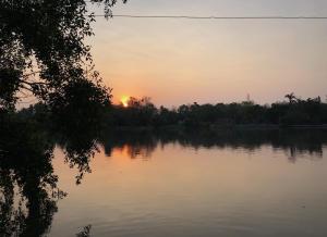 a sunset over a body of water at ี เรือนปณาลี รีสอร์ท in Ban Khlong Sai Yok