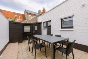 une table noire et des chaises sur une terrasse dans l'établissement Maison Elice, à La Panne