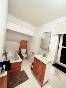 ein Badezimmer mit einem Waschbecken, einer Badewanne und einem WC in der Unterkunft Le mazot d’Edouard et Celestin in Profondeville