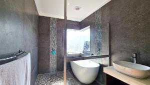La salle de bains est pourvue d'un lavabo, de toilettes et d'une douche. dans l'établissement Sea Views on 14th, à East London